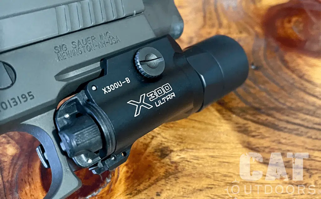SureFire X300U-B Ultra mounted on a SIG Sauer P226 frame, close-up on a wood table
