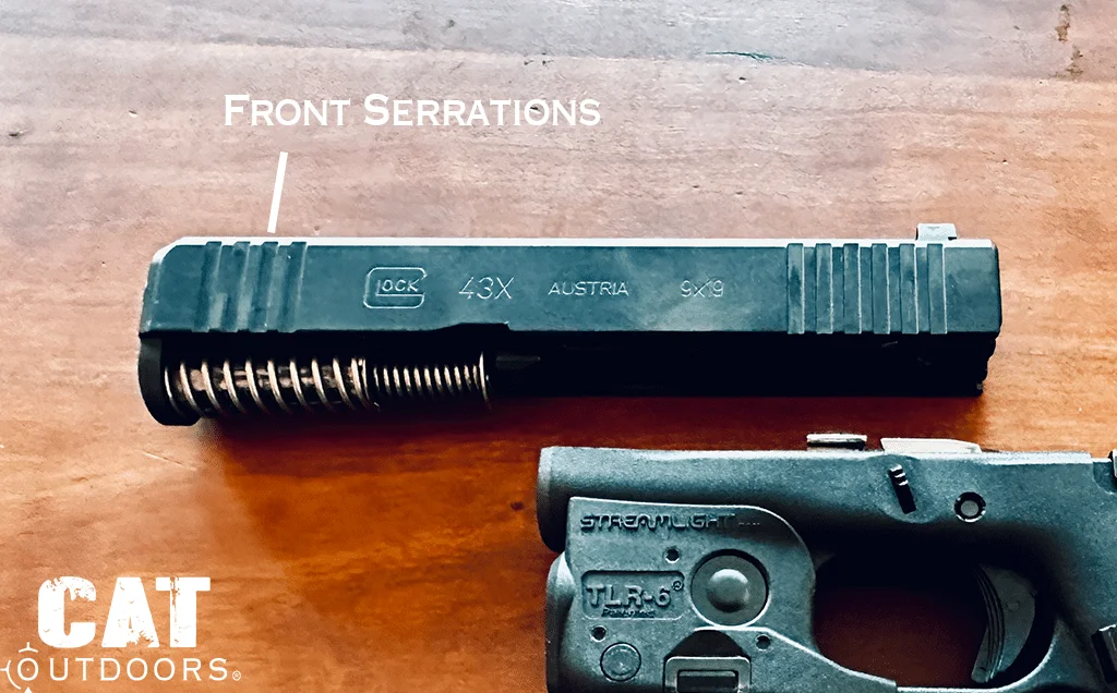 Slide removed from the Glock 43X with a white label pointing to the front serrations