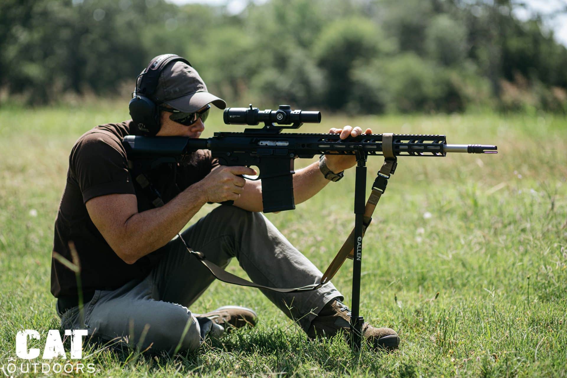 Shooter kneeling in a field using an AR-15 with a Vortex Strike Eagle LPVO mounted on a bipod for stable aiming