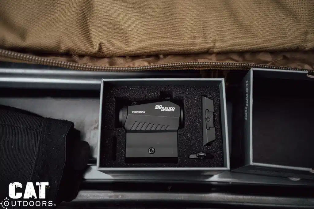 SIG Romeo 5 seated in its open foam-lined box beside the lid, extra mount hardware in the cutouts