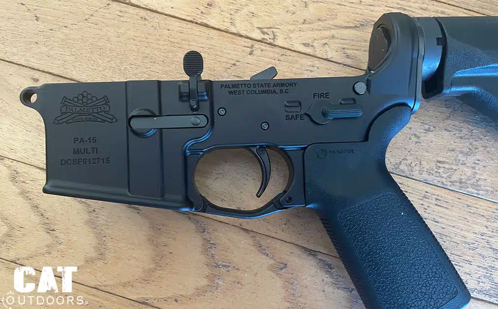 Geissele SSA-E curved trigger installed in a Palmetto State Armory lower receiver on a wood floor