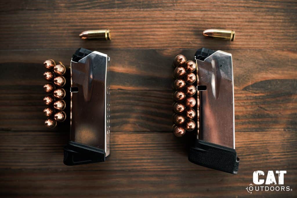 Top-down view of the Springfield Hellcat 11-round flush and 13-round extended magazines side by side with FMJ ammunition lined up next to each