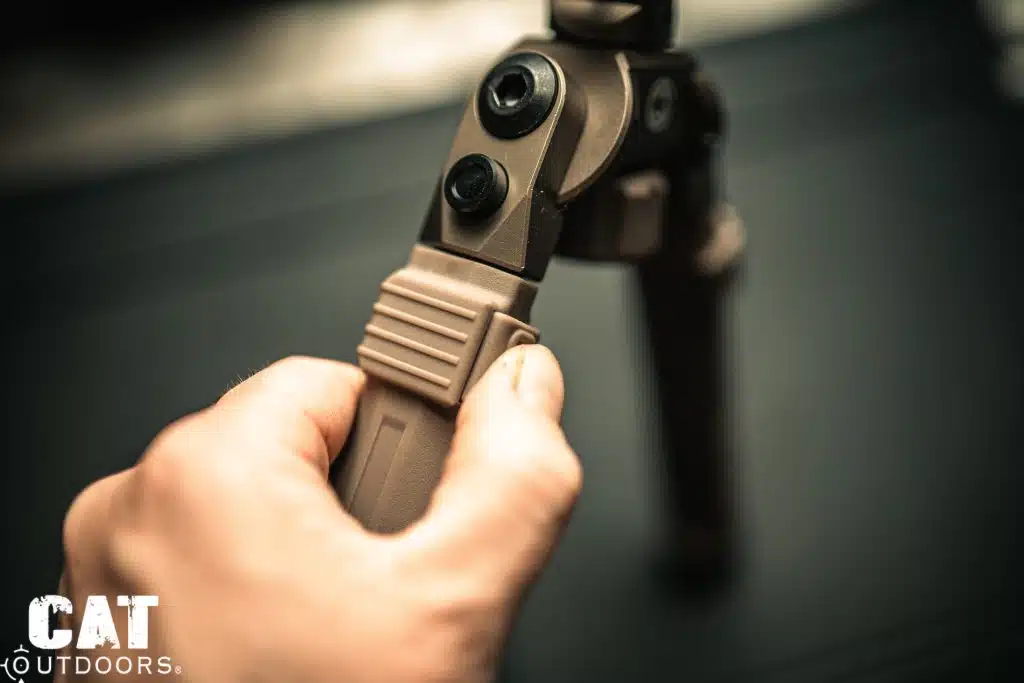 Hand pressing the CVLIFE bipod leg detent release button