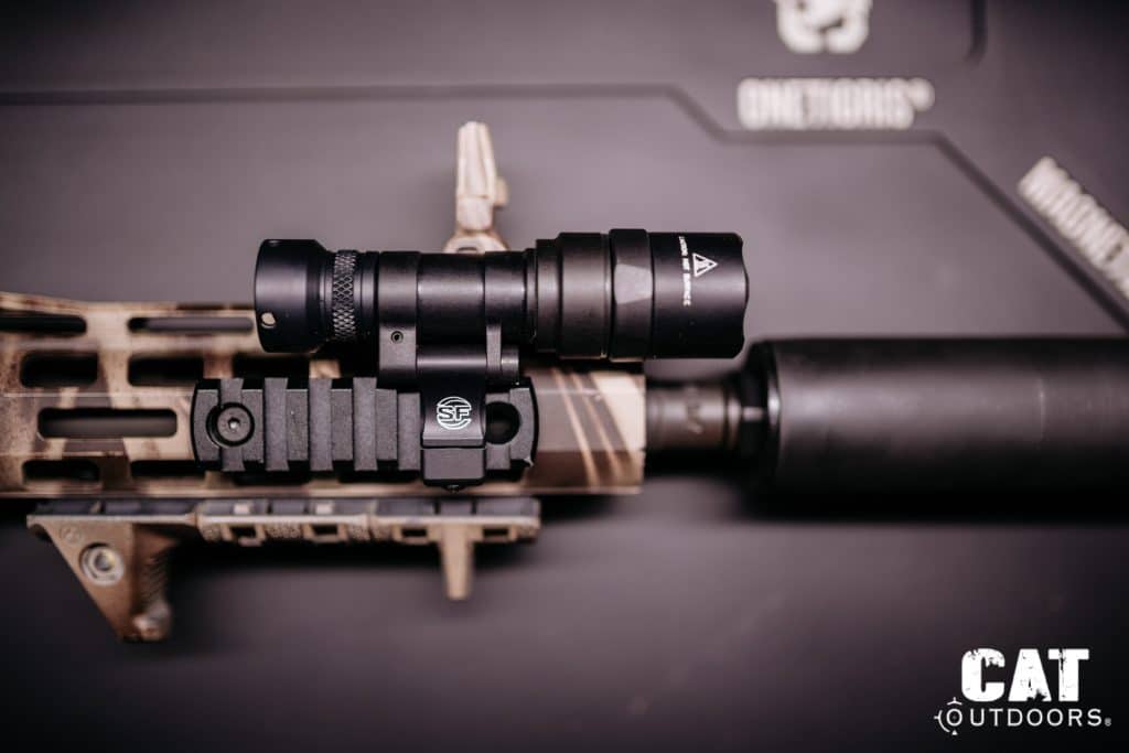 Light mounted via Picatinny rail adapter directly onto an FDE M-LOK handguard, top-down view