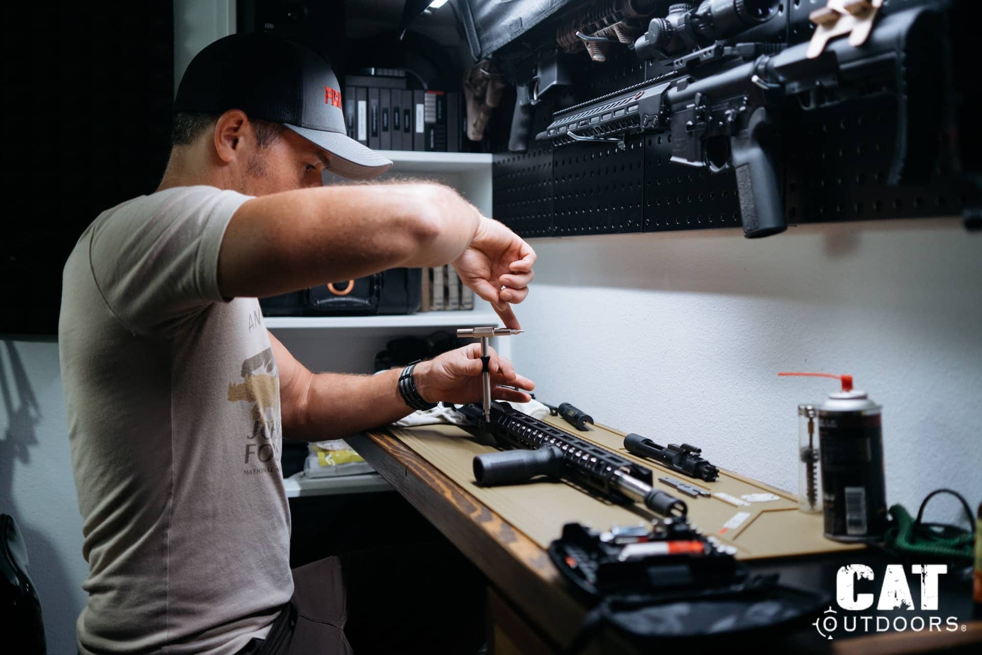 Bradley Lanphear running detailed maintenance on an AR-15 at the CAT Outdoors workbench