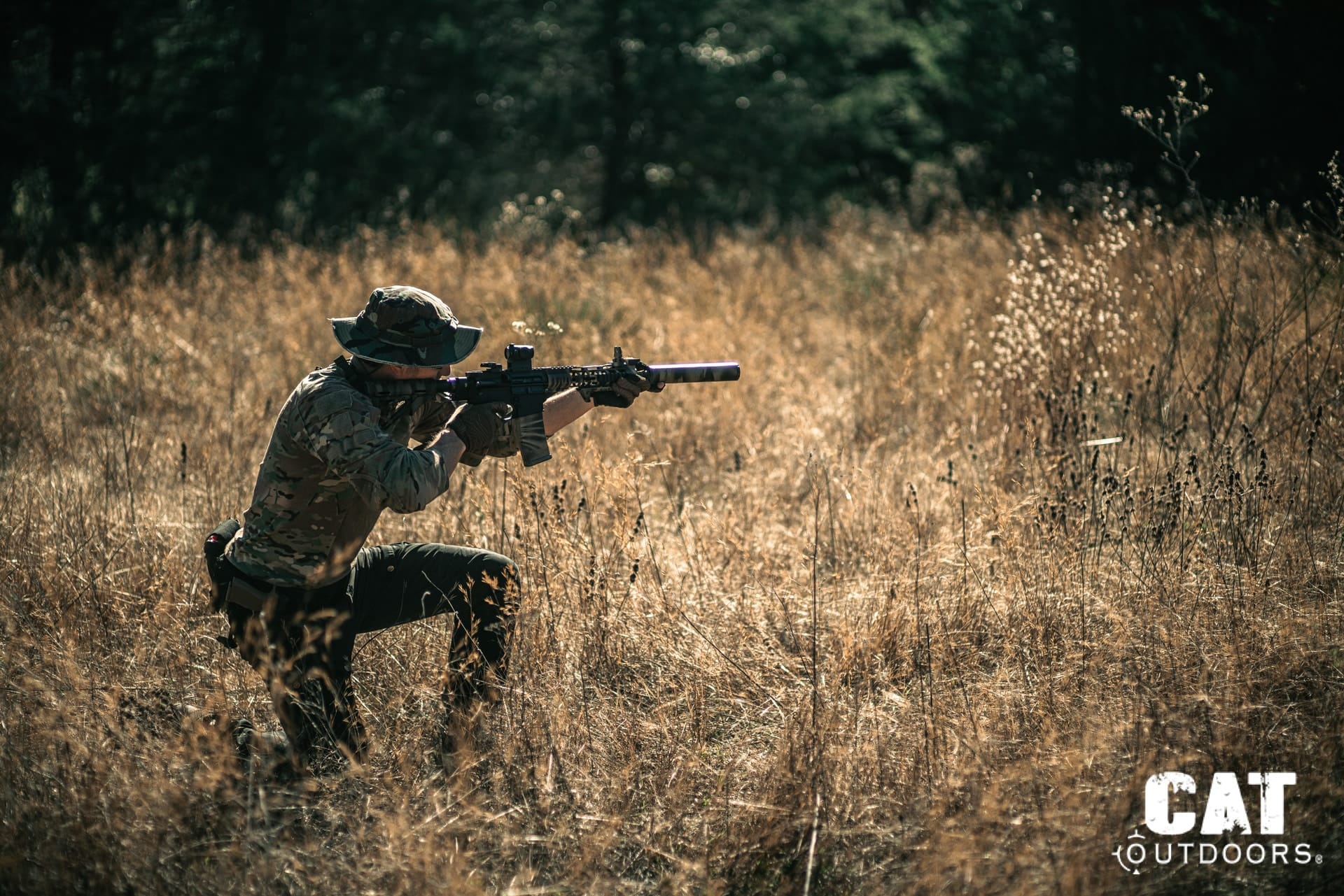 CAT Outdoors team member with suppressed AR-15 in late-afternoon field testing conditions