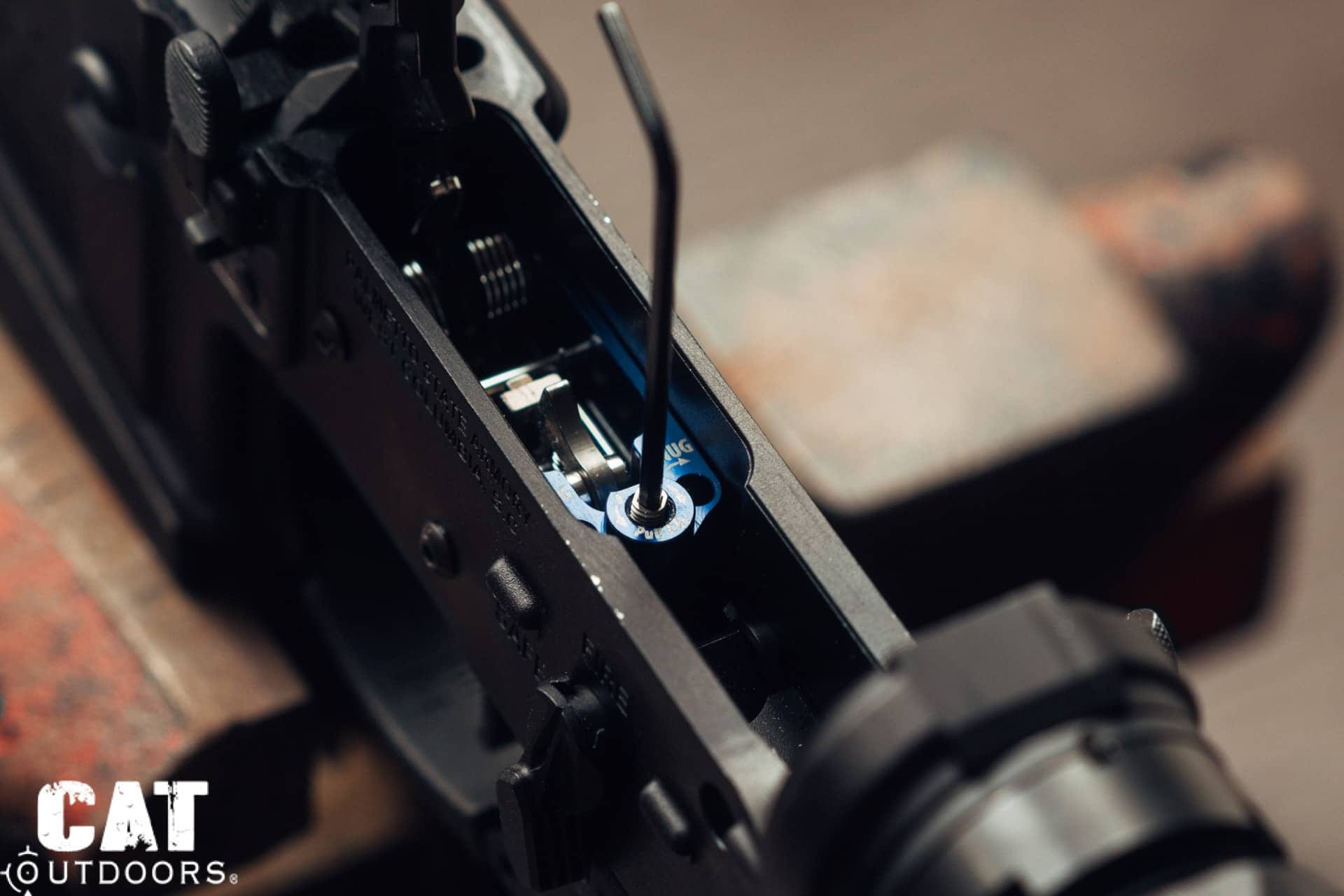 Adjusting the TriggerTech Diamond pull weight set screw with an Allen key inside an AR-15 lower receiver