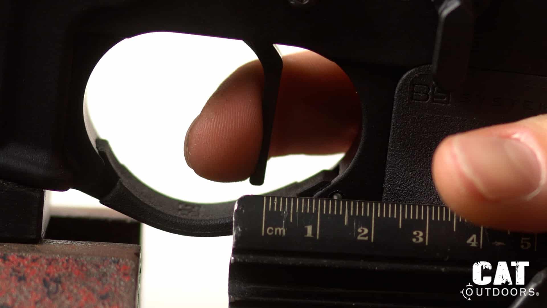 TriggerTech Diamond flat trigger shoe at rest against a metric ruler at the start of its 1.5 mm travel measurement