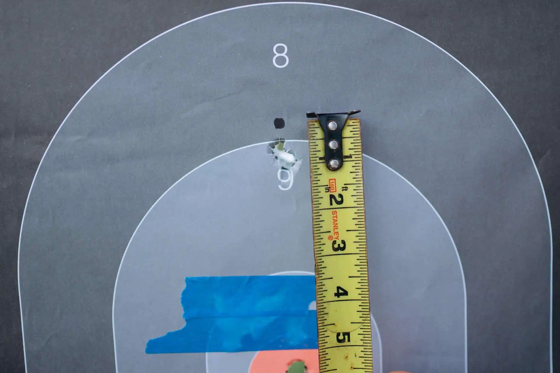 Baseline 25-yard group measured with a tape, landing where expected for a provisional 50-yard zero