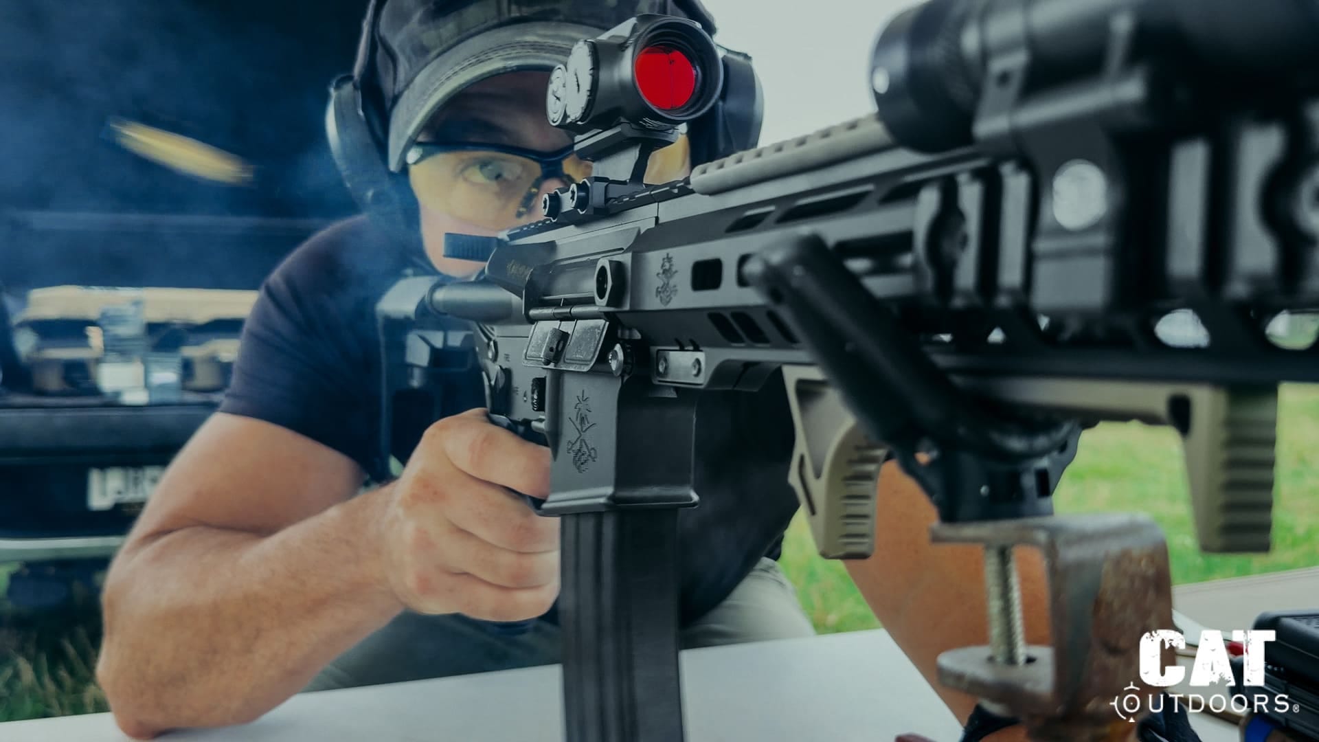 PSA Sabre 300 Blackout build: Brad shooting rifle from table. Cartridge in mid-air