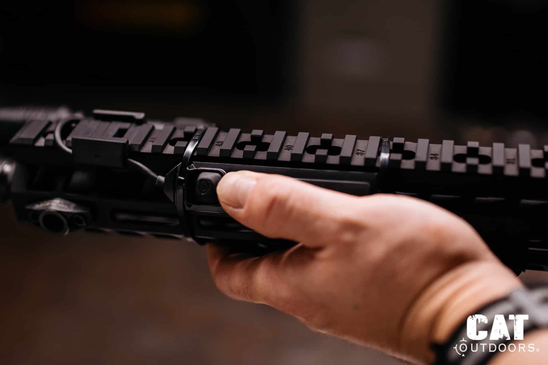 Hand on the handguard reaching the ProTac Rail Mount 1 switch