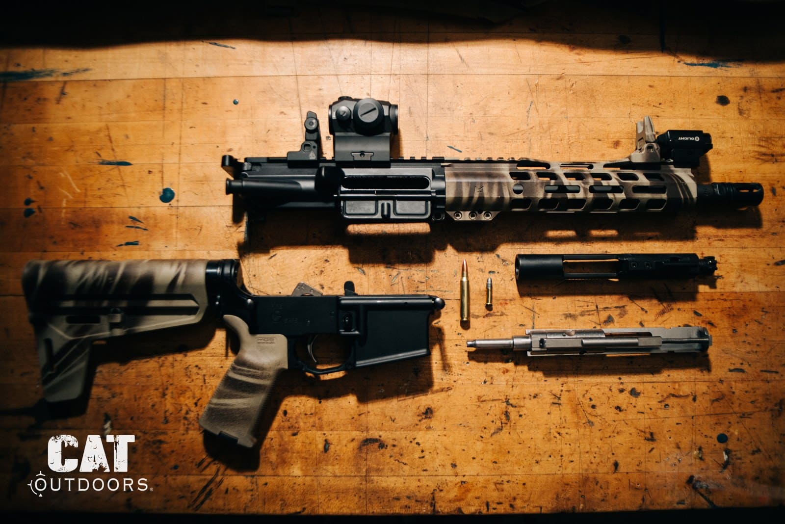 AR pistol disassembled on a workbench: upper, lower, brace, bolt carrier group and barrel