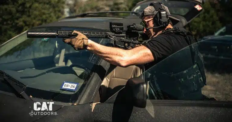 Shooter with a semi-automatic AR-15 rifle braced over a vehicle hood
