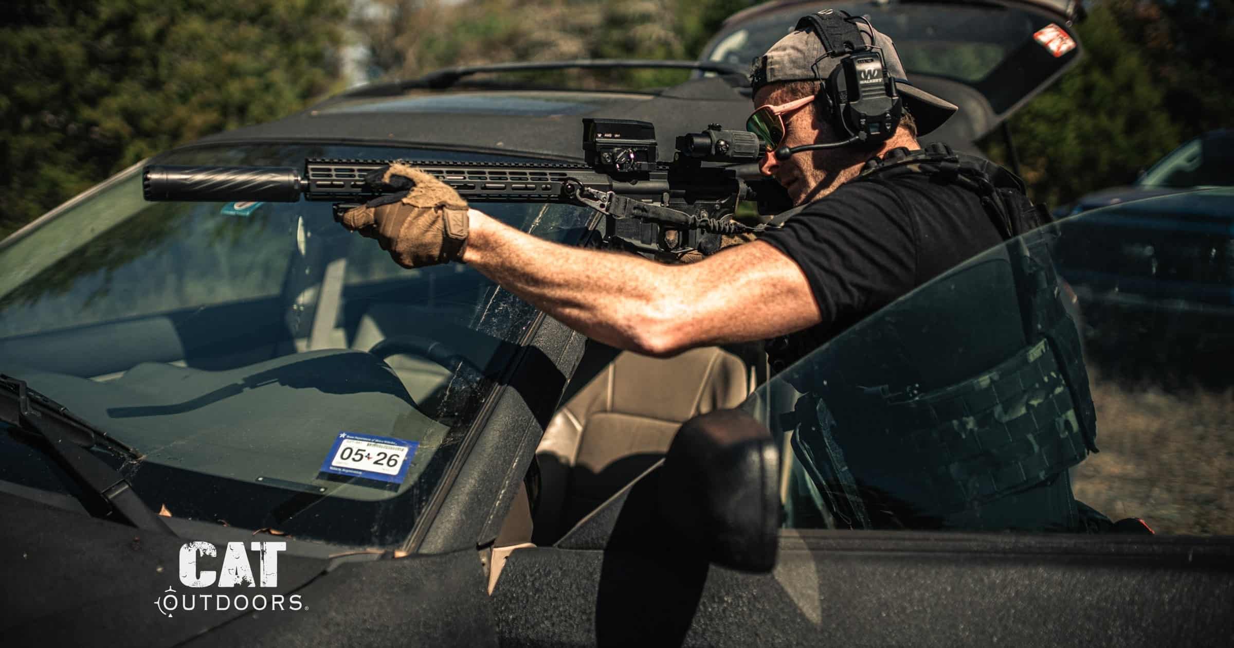 Shooter with a semi-automatic AR-15 rifle braced over a vehicle hood