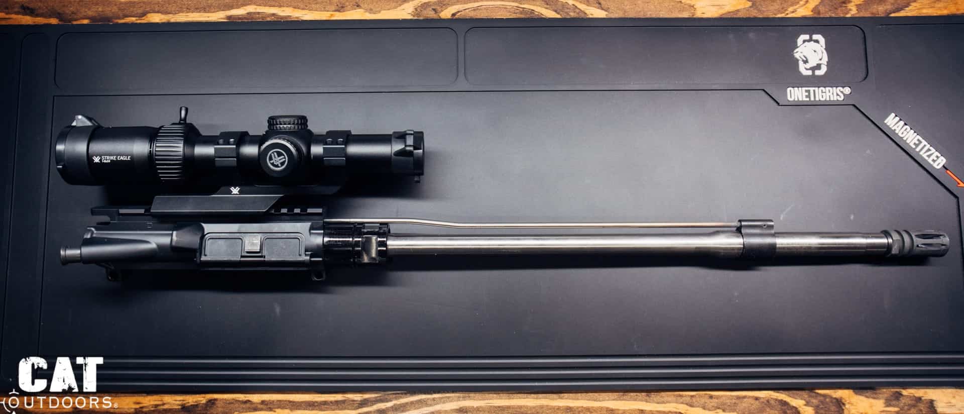 Bare AR-15 barrel and upper receiver laid on a bench mat