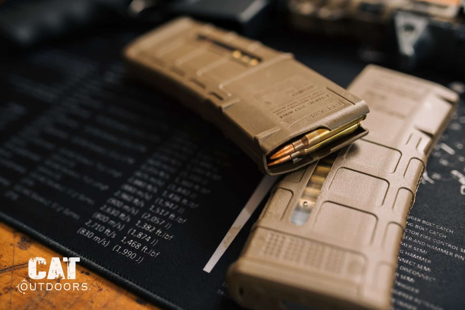 Two loaded Magpul 30-round PMAG magazines on a bench mat