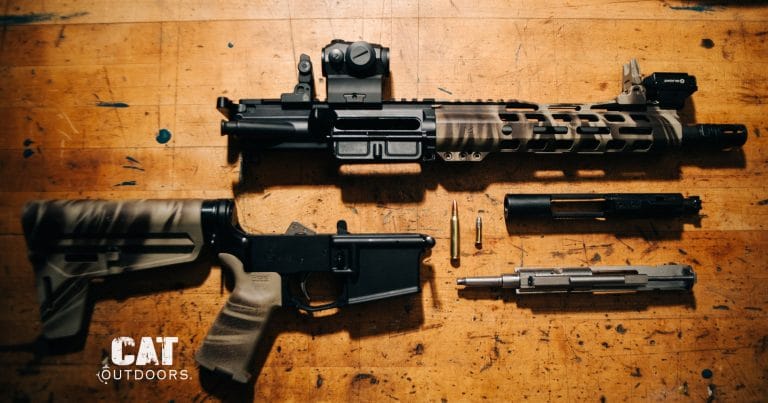 Disassembled AR-15 pistol on a workbench: upper receiver, stripped lower, bolt carrier group and barrel laid out