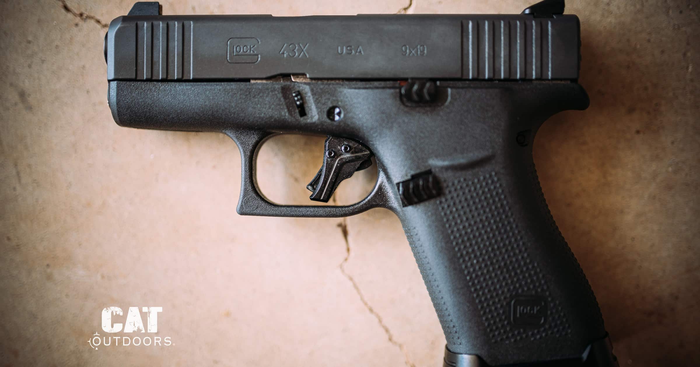 Glock 43X 9mm pistol lying on a concrete bench