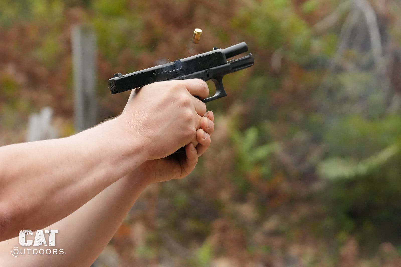 Glock 19 Gen 5 at full recoil with the slide back, a brass case in the air and smoke at the muzzle