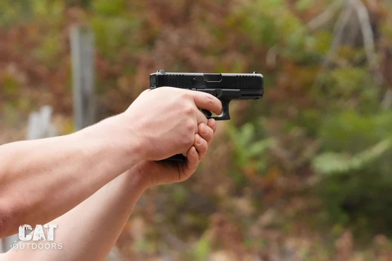 Two-handed grip on the Glock 19 Gen 5 at full extension, left side of the gun