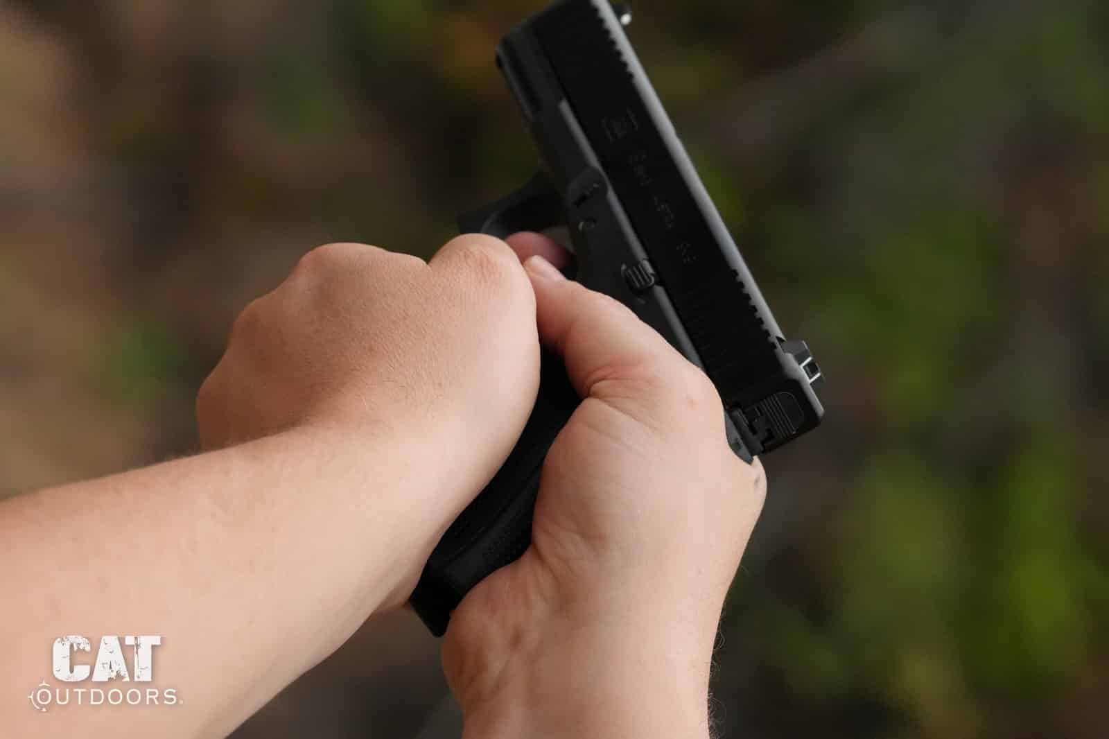 Rear view of the Glock 19 Gen 5 in a two-handed grip showing the factory polymer rear sight