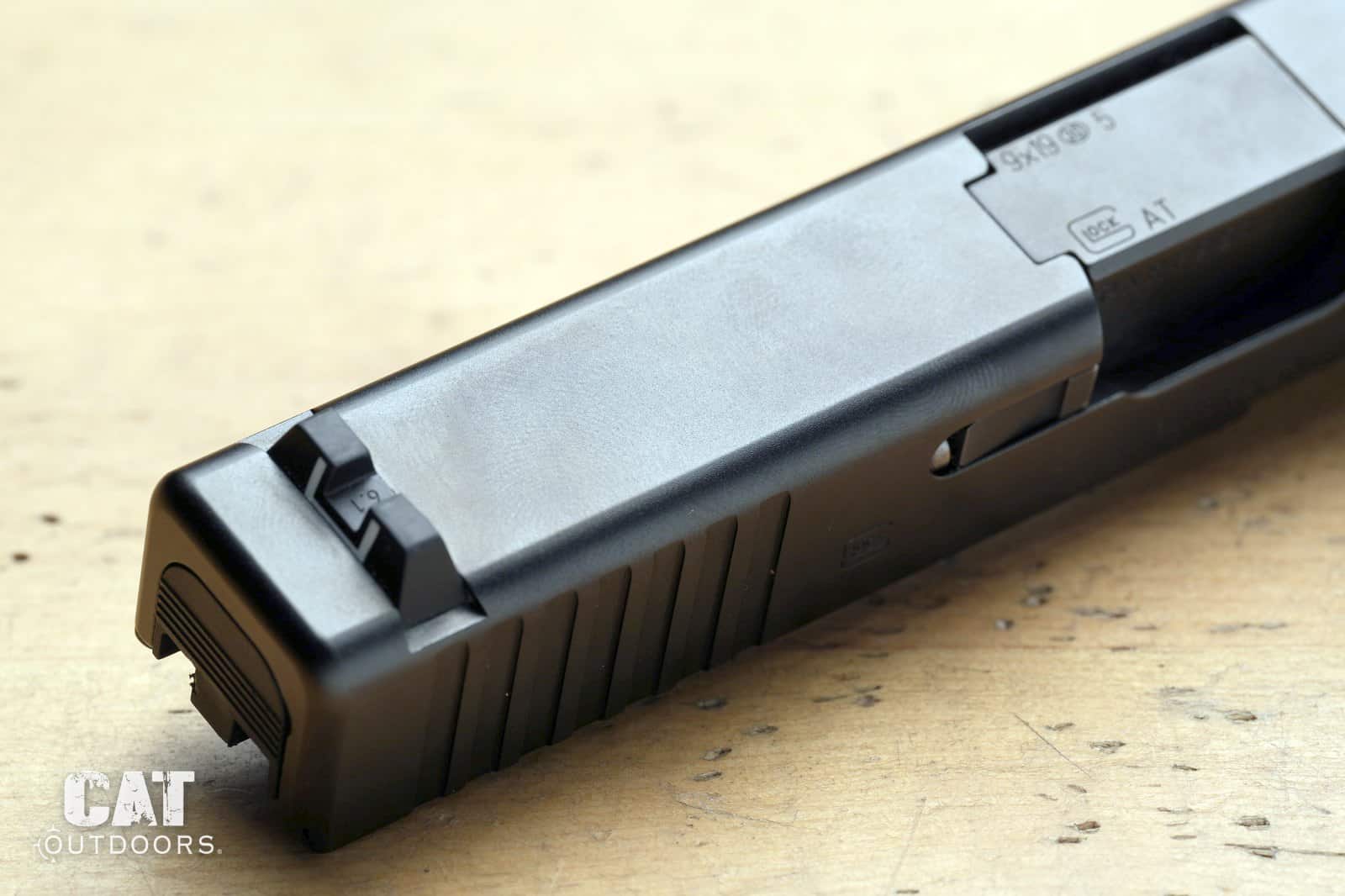 Top of the Glock 19 Gen 5 slide with no optic cut, showing the rear sight and holster wear on the finish