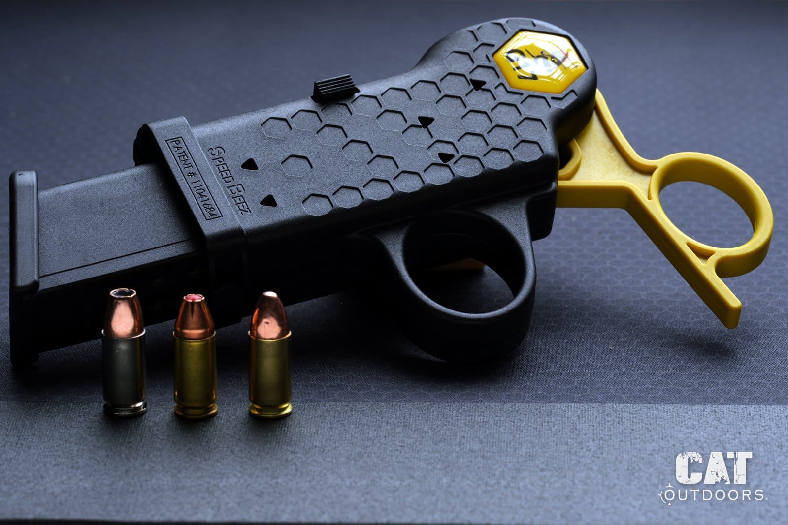 Ball, steel case and hollow point 9mm rounds beside the Speed Beez loader with a magazine seated