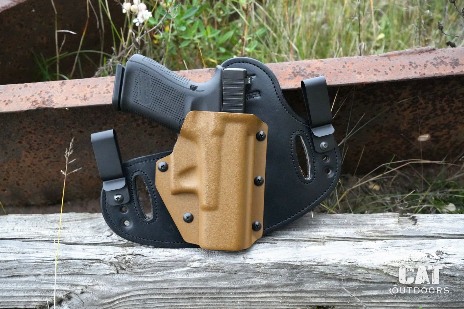 Hidden Hybrid Double Clip IWB/OWB holster with a Glock 19 on a rusted steel beam