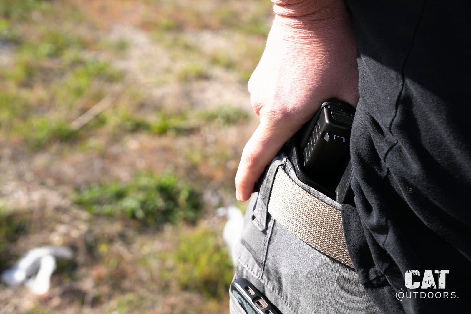 Reaching back to the Hidden Hybrid holster at 5 o'clock