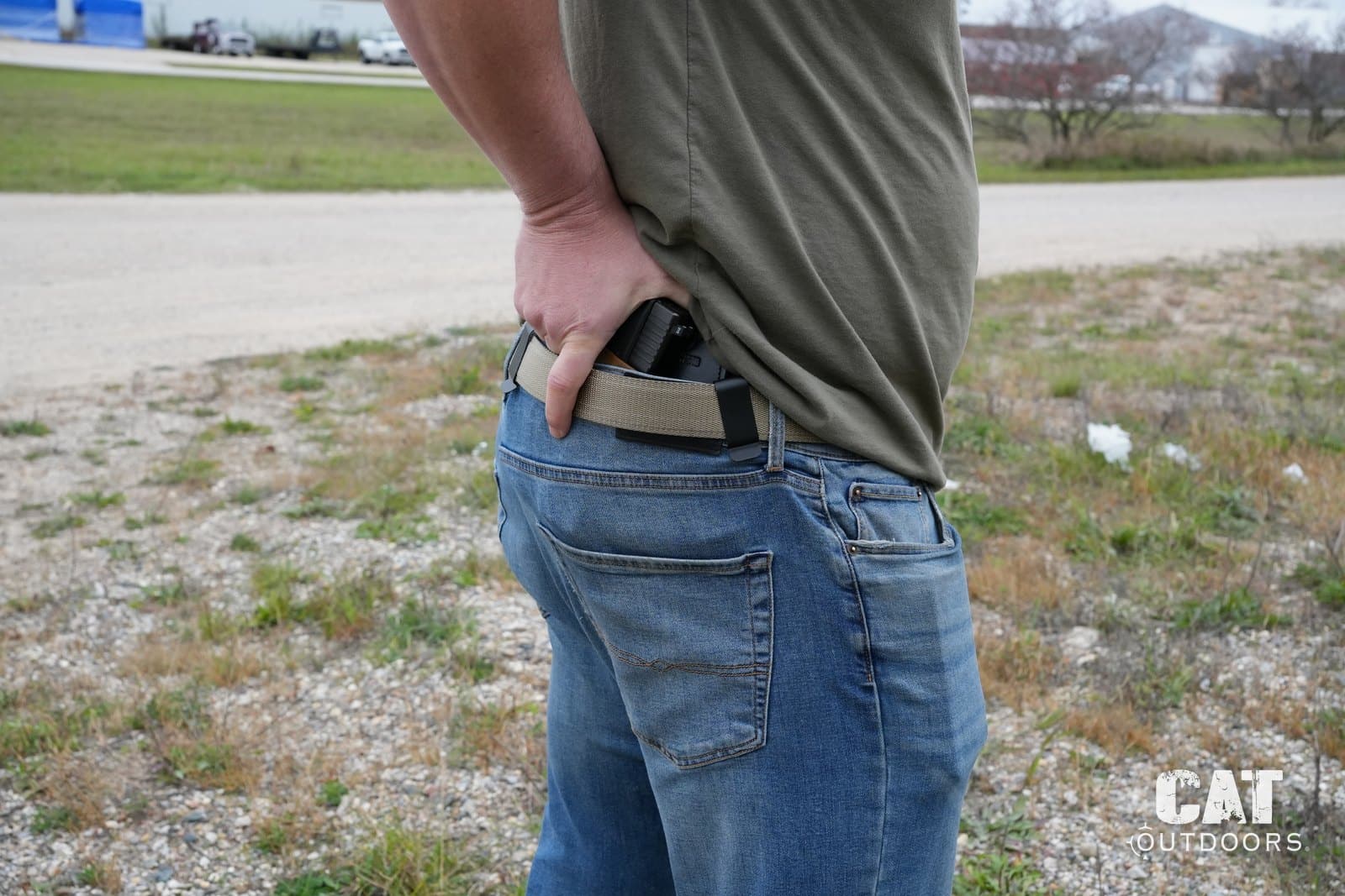 Hidden Hybrid Double Clip carried inside the waistband under a T-shirt, hand on the grip