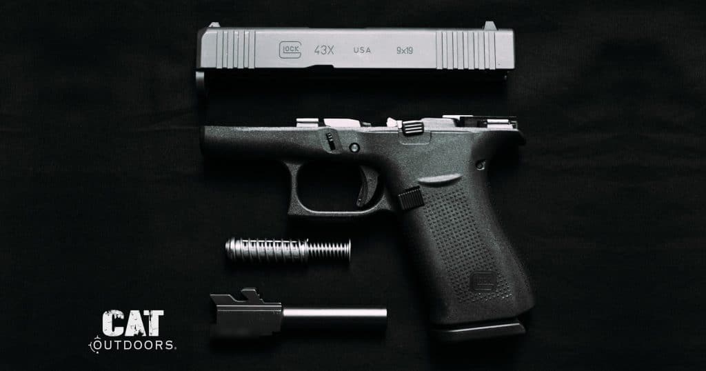 Field-stripped Glock 43X pistol showing the slide, frame, recoil spring, and barrel
