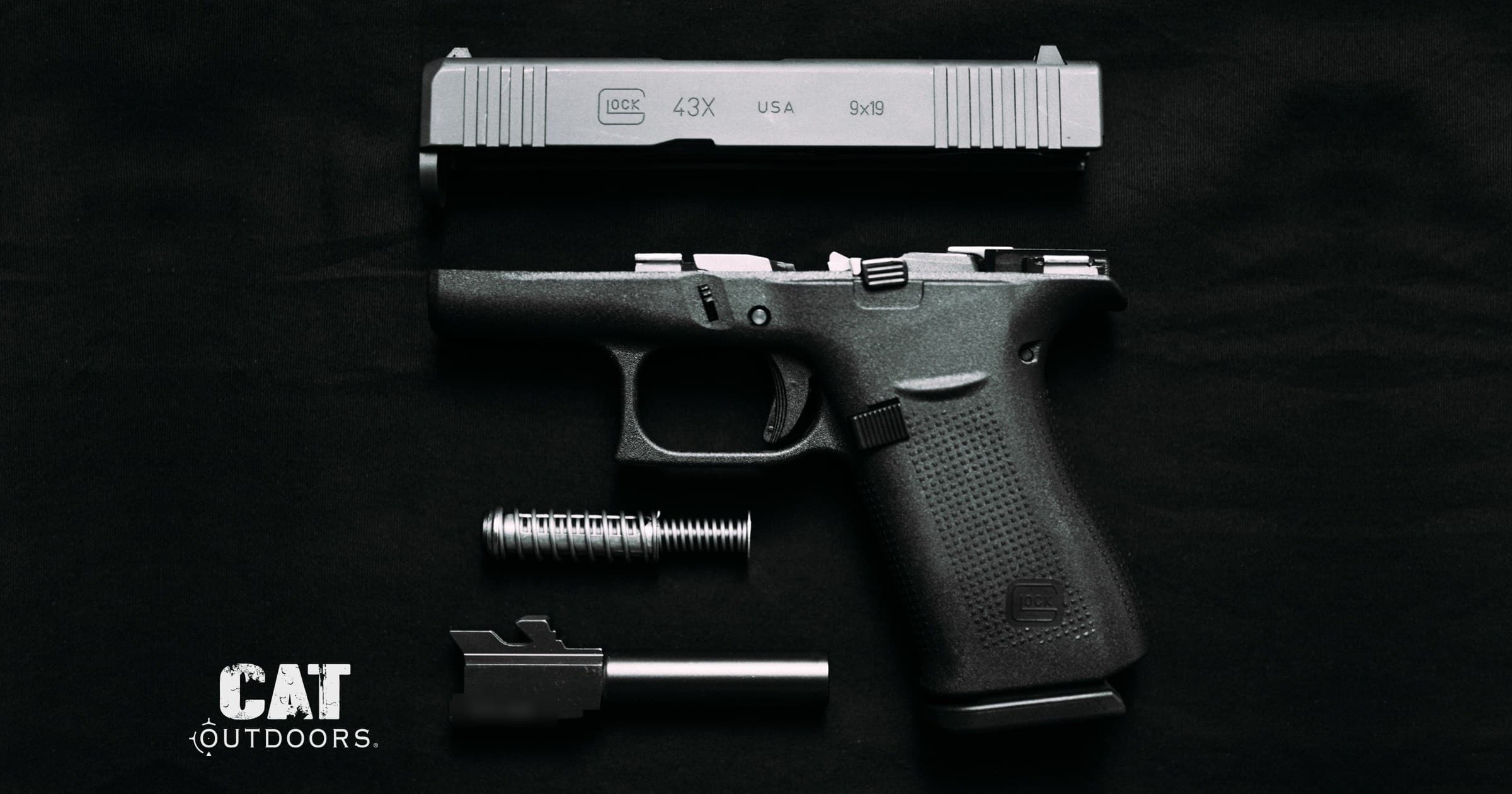 Field-stripped Glock 43X pistol showing the slide, frame, recoil spring, and barrel