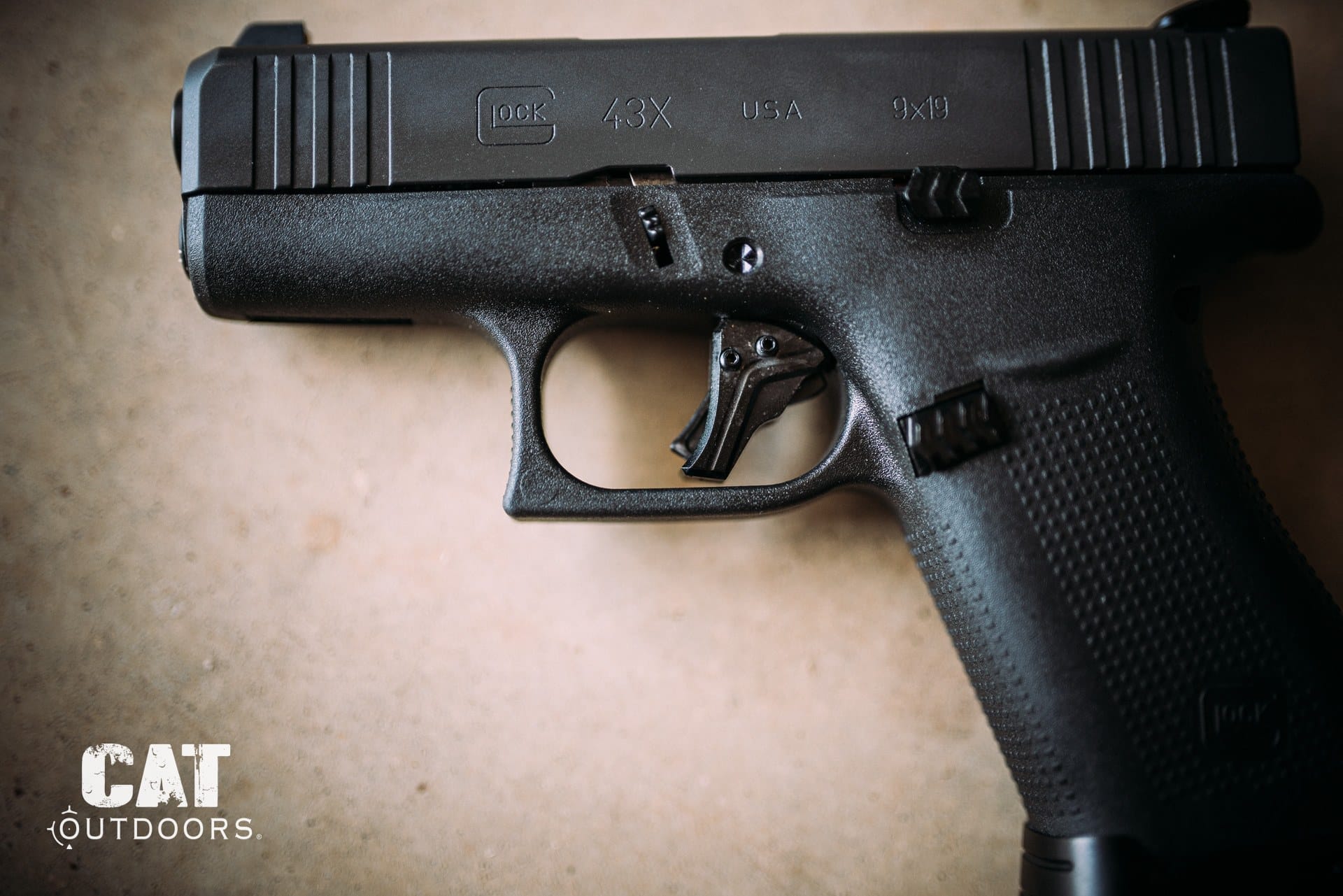 Glock 43X Slimline pistol on a concrete surface