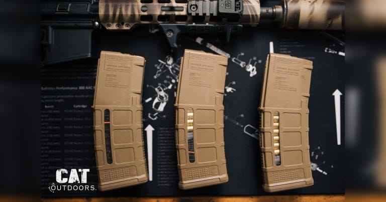 AR-15 rifle and three 30-round Magpul PMAG magazines on a workbench mat