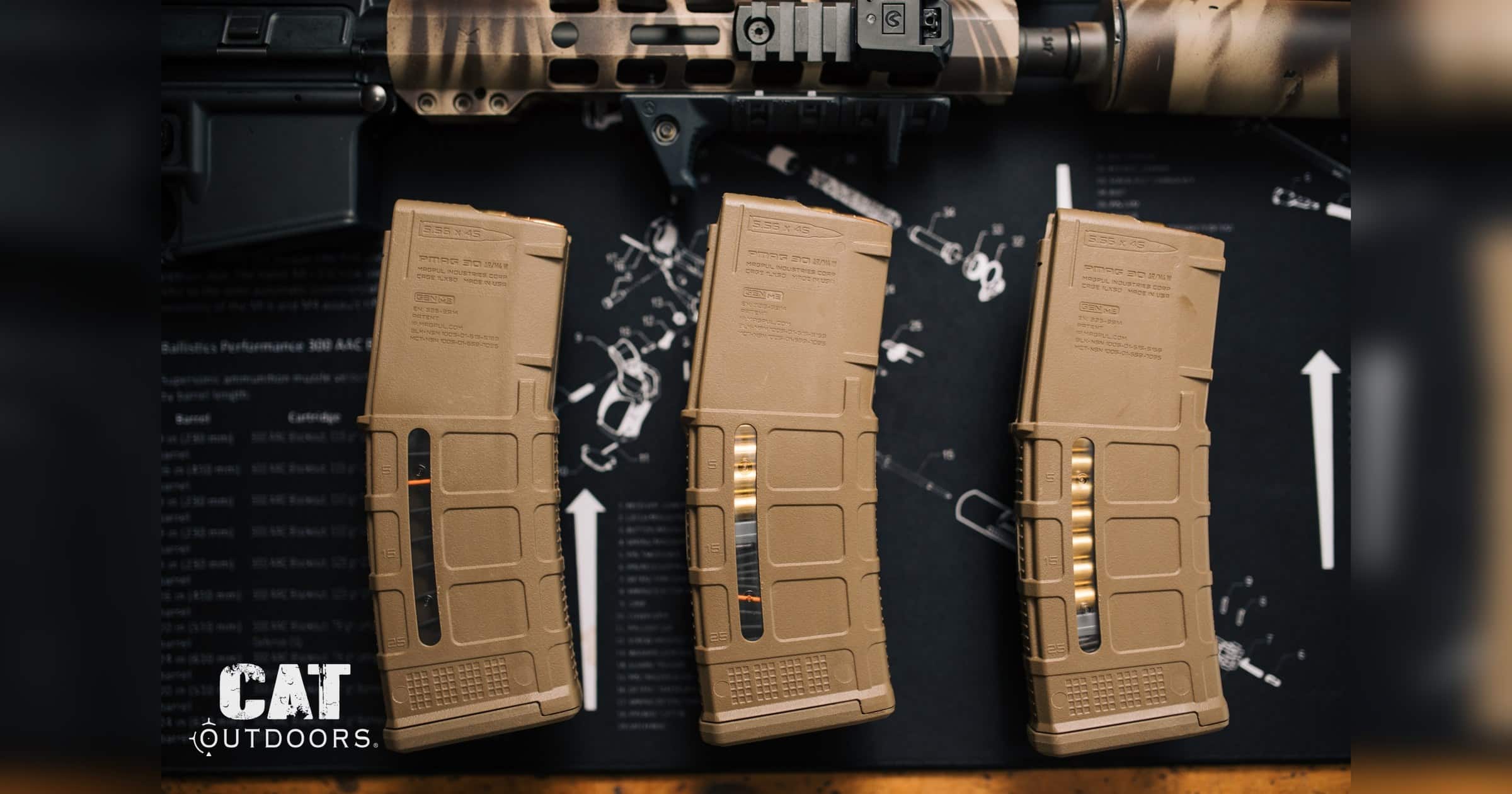 AR-15 rifle and three 30-round Magpul PMAG magazines on a workbench mat